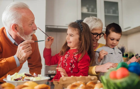 Grandparents sharing a meal with young children at the dining table, smiling and enjoying food together