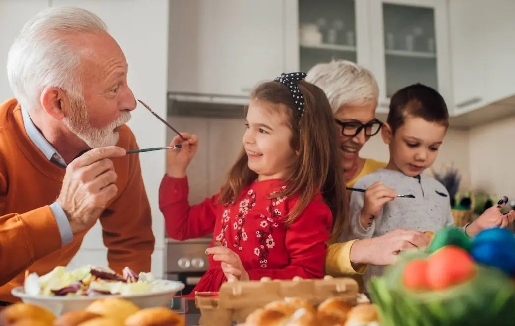 Grandparents sharing a meal with young children at the dining table, smiling and enjoying food together